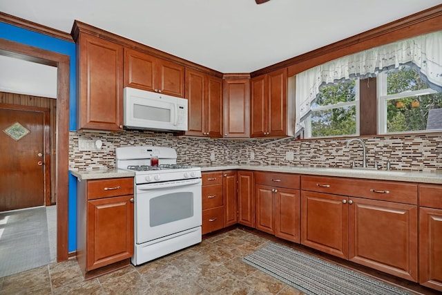 kitchen with white appliances, decorative backsplash, brown cabinetry, light countertops, and a sink