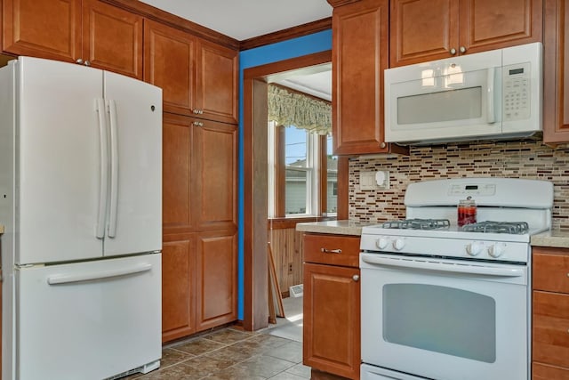 kitchen with white appliances, tasteful backsplash, brown cabinetry, and light countertops