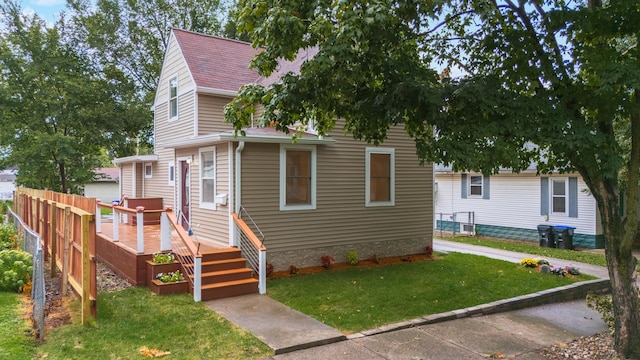 view of front facade featuring a deck and a front lawn