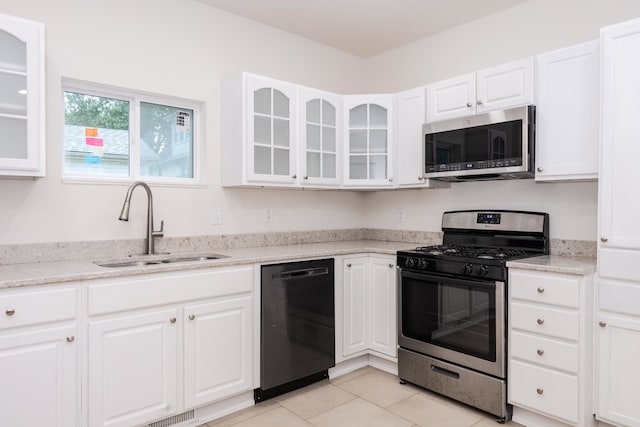 kitchen featuring light tile patterned floors, stainless steel appliances, sink, and white cabinetry