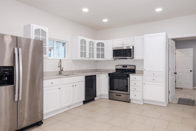 kitchen featuring light stone countertops, white cabinetry, appliances with stainless steel finishes, and sink