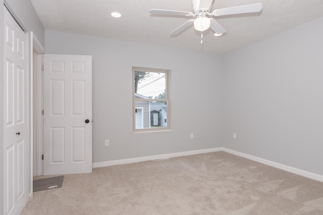 interior space with light carpet and ceiling fan