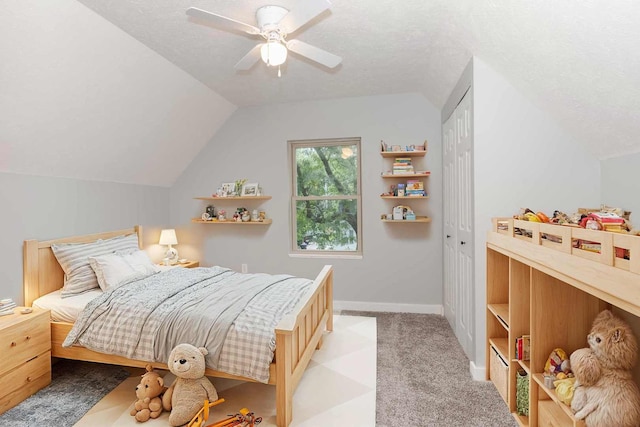 bedroom featuring vaulted ceiling, light carpet, ceiling fan, and a closet