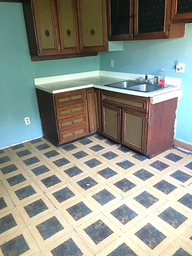 kitchen with sink, dark brown cabinetry, and light tile patterned flooring