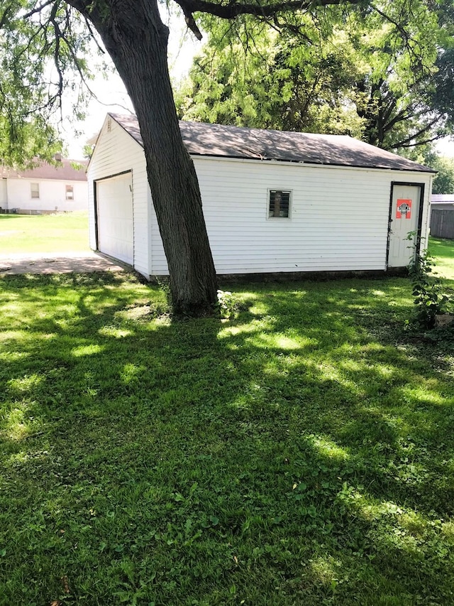 exterior space with a garage and an outbuilding