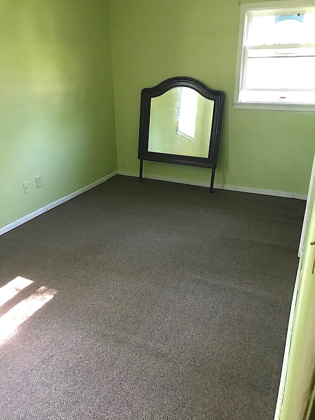 unfurnished room with baseboards