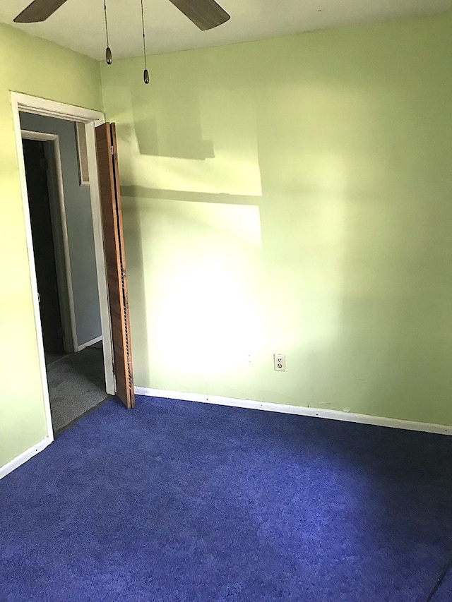 empty room featuring ceiling fan, baseboards, and carpet flooring