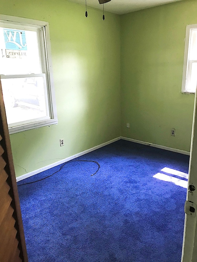 carpeted empty room featuring baseboards