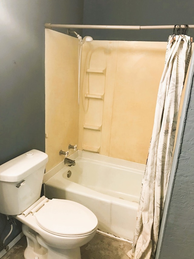 bathroom featuring toilet and shower / tub combo with curtain