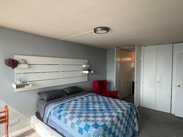 bedroom featuring a textured ceiling and dark carpet