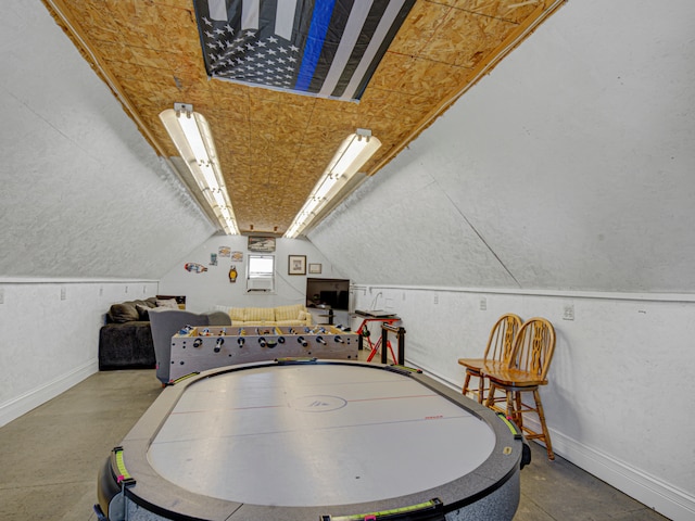 rec room with lofted ceiling and concrete flooring