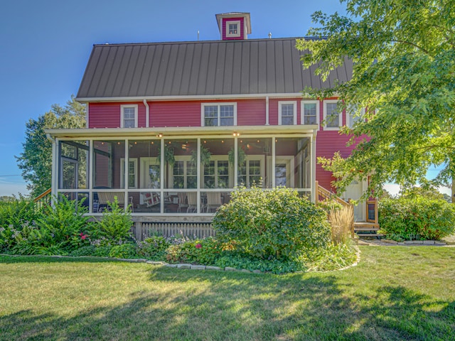 view of front of home featuring a sunroom and a front yard