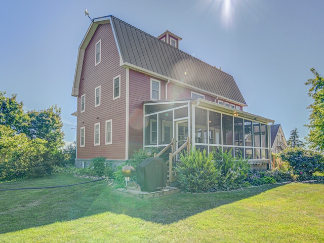 rear view of property with a sunroom and a yard