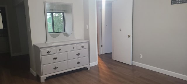 corridor with dark hardwood / wood-style flooring