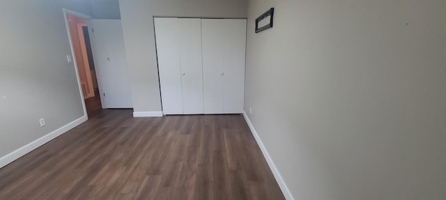 unfurnished bedroom featuring dark hardwood / wood-style floors and a closet