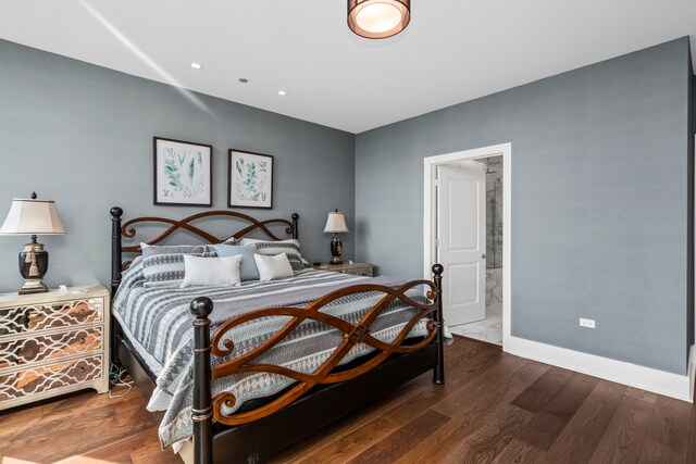 bedroom with ensuite bathroom and dark hardwood / wood-style floors