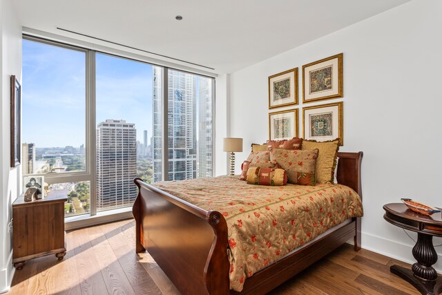 bedroom featuring hardwood / wood-style floors and a wall of windows