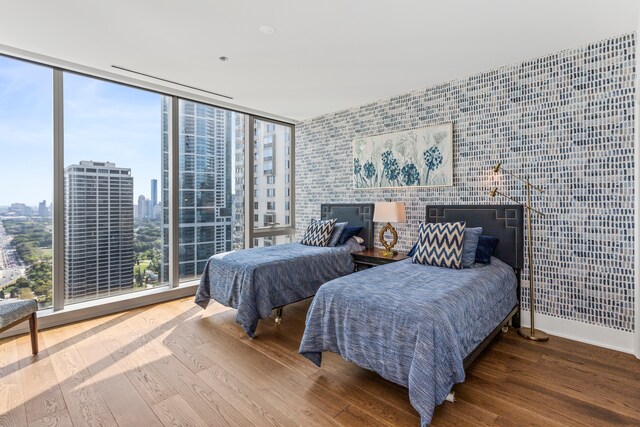 bedroom featuring hardwood / wood-style floors, expansive windows, and multiple windows