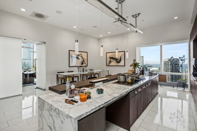 kitchen with a wealth of natural light, hanging light fixtures, and dark brown cabinetry