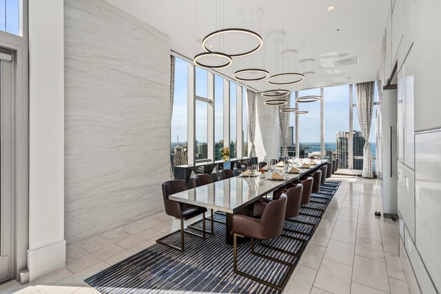 dining area with a wall of windows, tile walls, a notable chandelier, and light tile patterned flooring