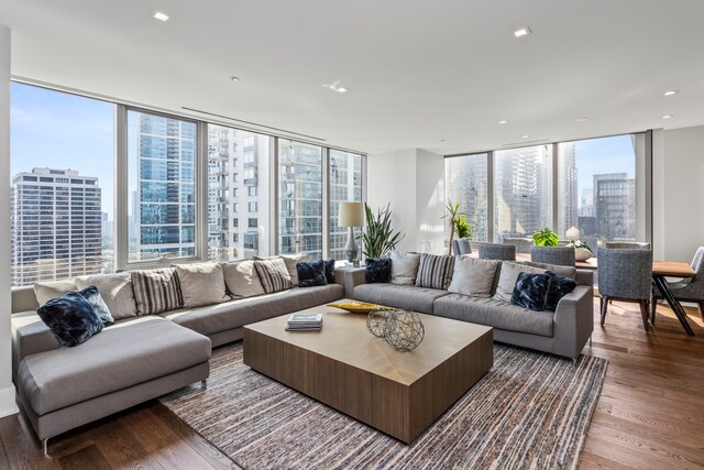 living room featuring a wealth of natural light, expansive windows, and wood-type flooring