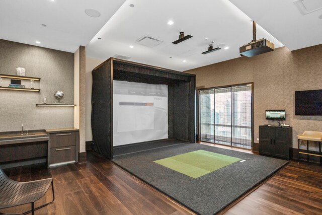 interior space with dark hardwood / wood-style flooring and golf simulator