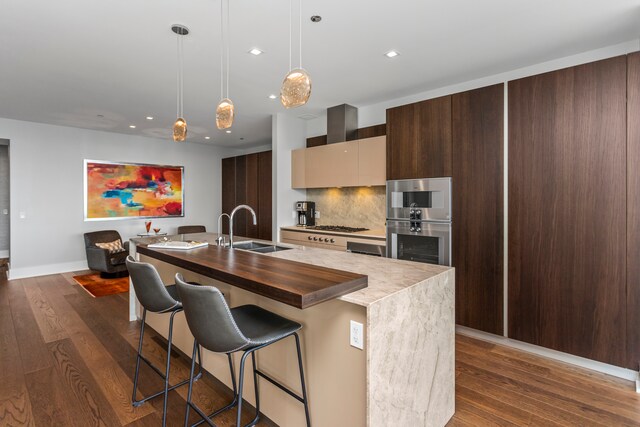 kitchen with decorative light fixtures, decorative backsplash, dark hardwood / wood-style flooring, and sink