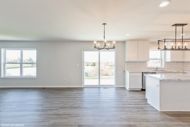 kitchen featuring white cabinetry, wood-type flooring, pendant lighting, and a wealth of natural light