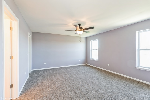 empty room with a wealth of natural light, carpet floors, and ceiling fan