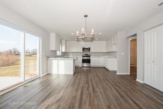 kitchen featuring appliances with stainless steel finishes, white cabinets, plenty of natural light, and dark hardwood / wood-style floors