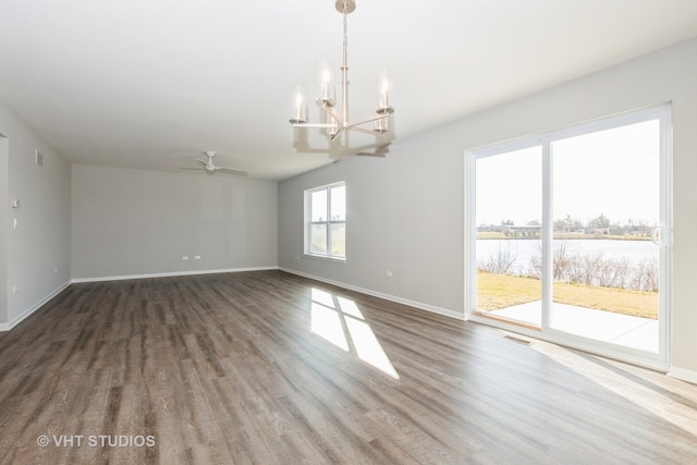 unfurnished room featuring hardwood / wood-style flooring, ceiling fan with notable chandelier, and a water view