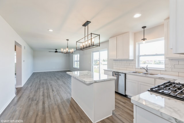 kitchen with dishwasher, white cabinetry, a center island, and plenty of natural light