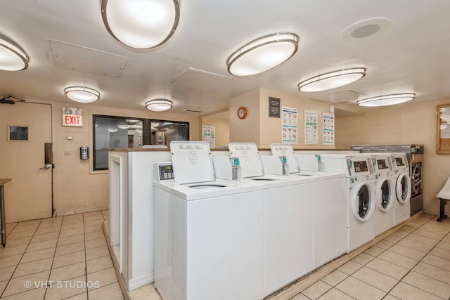 laundry area with separate washer and dryer and light tile patterned flooring