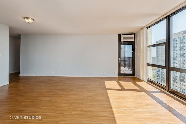 unfurnished room with light hardwood / wood-style floors and a wall mounted AC