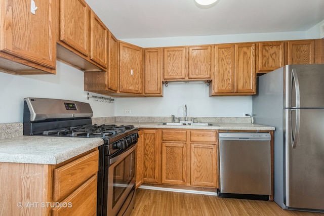 kitchen featuring appliances with stainless steel finishes, light wood-type flooring, and sink