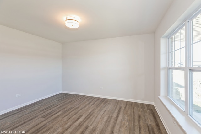 spare room featuring dark hardwood / wood-style flooring and plenty of natural light