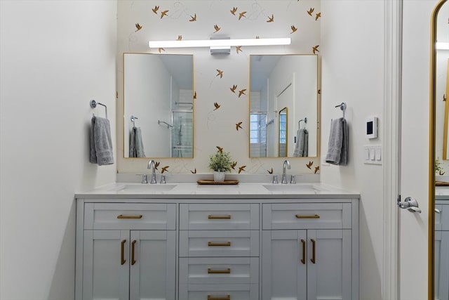 bathroom featuring a shower with door and vanity