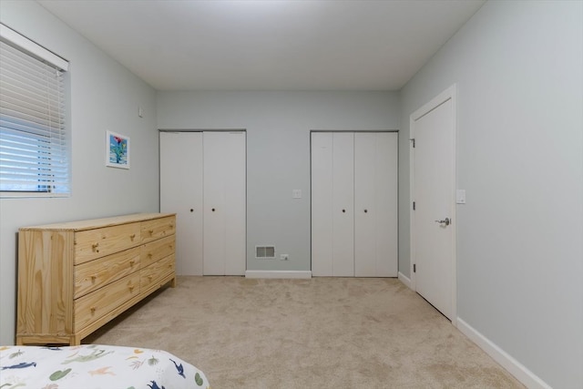 carpeted bedroom featuring two closets