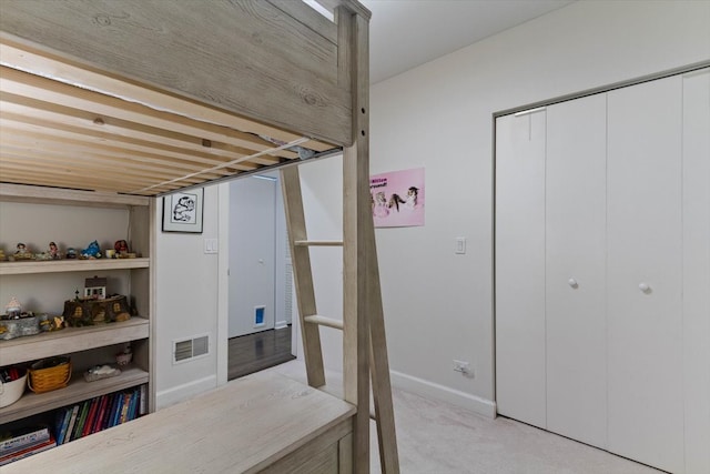 bedroom featuring light colored carpet and a closet