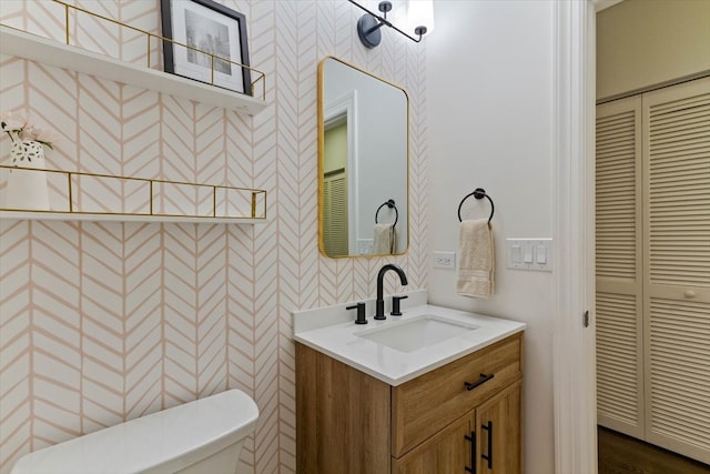 bathroom featuring toilet, hardwood / wood-style flooring, and vanity