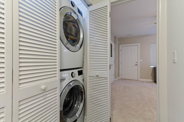 clothes washing area featuring light colored carpet and stacked washer / dryer