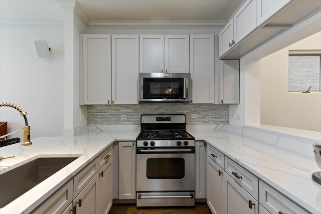 kitchen with crown molding, light stone counters, stainless steel appliances, and sink