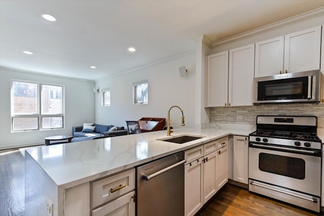 kitchen featuring hardwood / wood-style floors, stainless steel appliances, kitchen peninsula, and sink