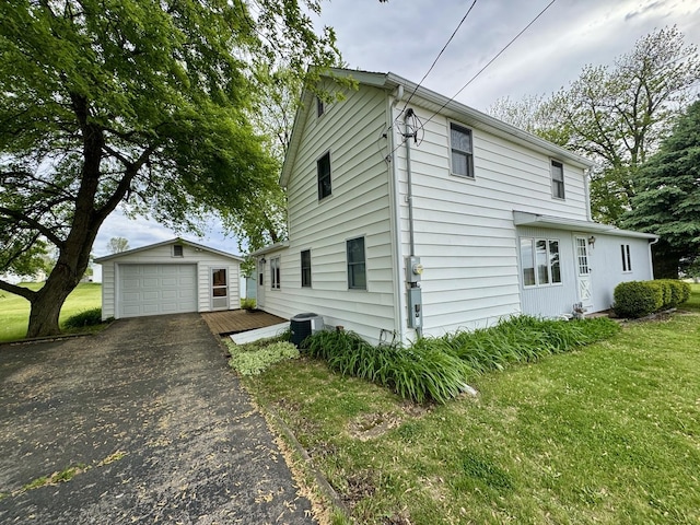 321 E N St, Sheffield, IL 61361 - view of home's exterior with an outbuilding, a detached garage, central AC unit, a lawn, and driveway