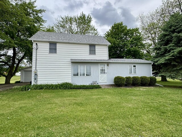 321 E N St, Sheffield, IL 61361 - view of front of home featuring a front yard, a garage, a shingled roof, and entry steps
