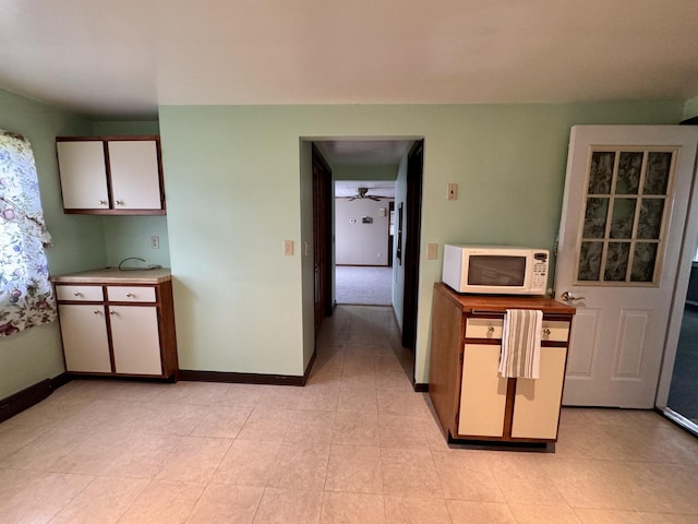 321 E N St, Sheffield, IL 61361 - kitchen with white microwave, baseboards, light countertops, and white cabinets