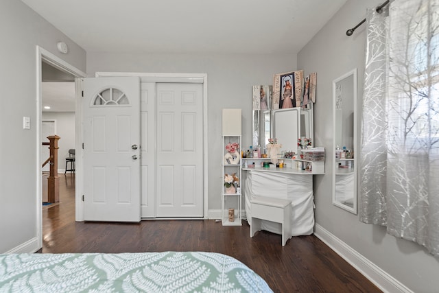 bedroom with multiple windows, dark hardwood / wood-style flooring, and a closet