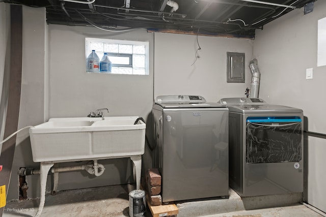 clothes washing area featuring electric panel, independent washer and dryer, and sink