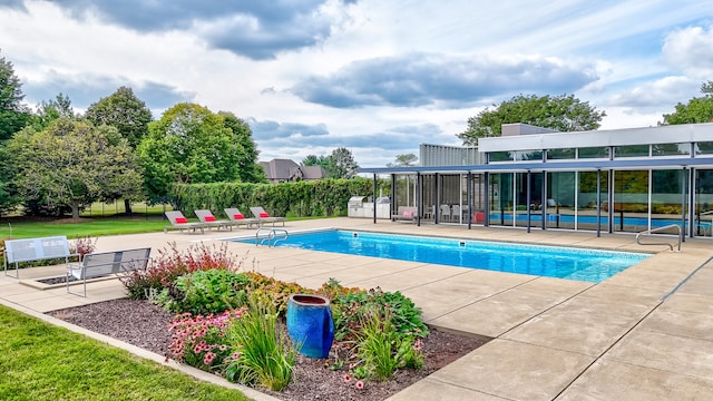 view of pool featuring a patio and a yard