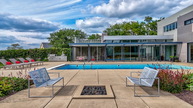 view of swimming pool featuring a fire pit and a patio area